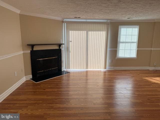 unfurnished living room featuring a textured ceiling, hardwood / wood-style flooring, and ornamental molding