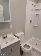 bathroom with a shower, toilet, and vanity