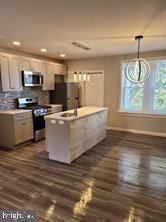 kitchen featuring dark hardwood / wood-style floors, stainless steel appliances, tasteful backsplash, and hanging light fixtures