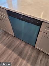 interior space with gray cabinets, dishwasher, and dark hardwood / wood-style flooring