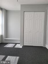 unfurnished bedroom with a closet and dark carpet