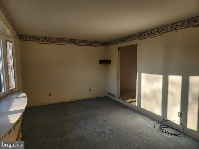 spare room with dark colored carpet