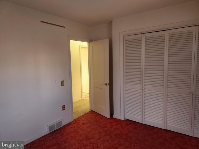 unfurnished bedroom featuring carpet flooring and a closet