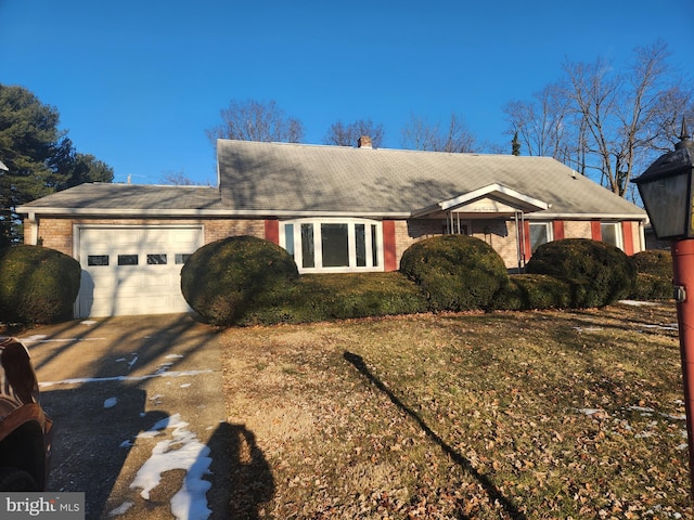 single story home with a garage and a front lawn