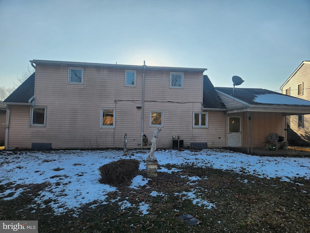 snow covered house featuring cooling unit