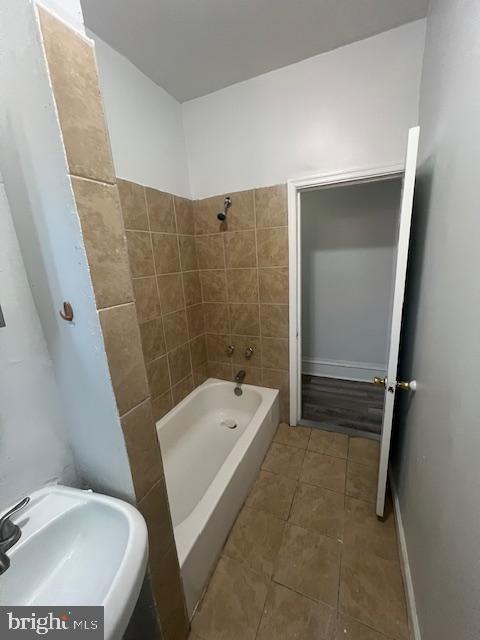 bathroom with tiled shower / bath combo and sink