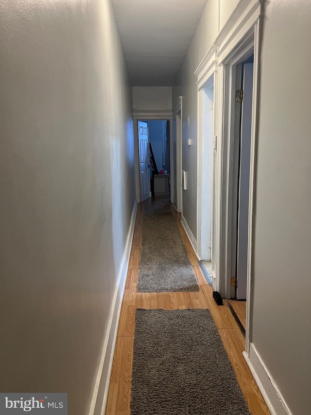 hallway with hardwood / wood-style flooring