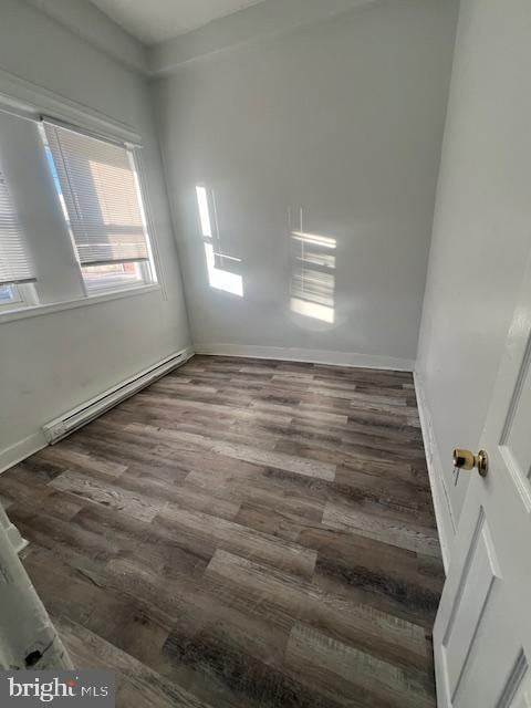 unfurnished room with wood-type flooring and a baseboard radiator