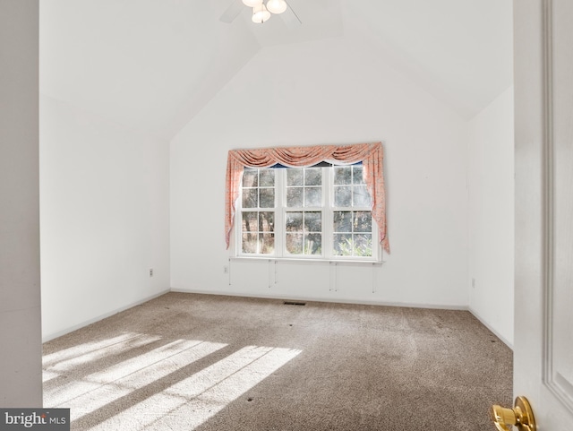 spare room featuring lofted ceiling, carpet floors, and ceiling fan