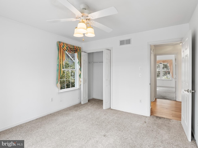 unfurnished bedroom featuring a closet, light carpet, and ceiling fan