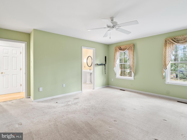 empty room featuring light colored carpet, ceiling fan, and sink