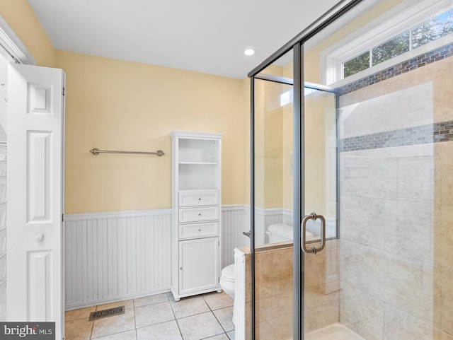 bathroom featuring an enclosed shower, tile patterned floors, and toilet