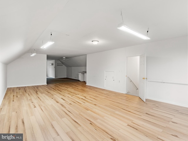 bonus room with ceiling fan, light hardwood / wood-style flooring, and vaulted ceiling