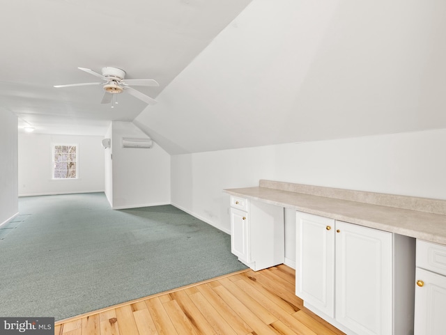 bonus room with a wall mounted air conditioner, ceiling fan, vaulted ceiling, and light wood-type flooring