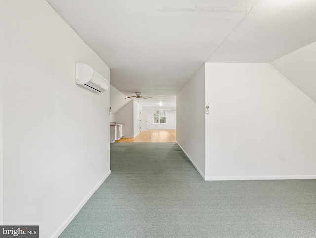 hallway with lofted ceiling, carpet, and a wall mounted AC