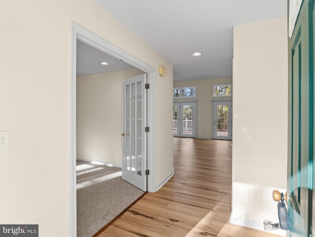 corridor featuring french doors and light hardwood / wood-style flooring