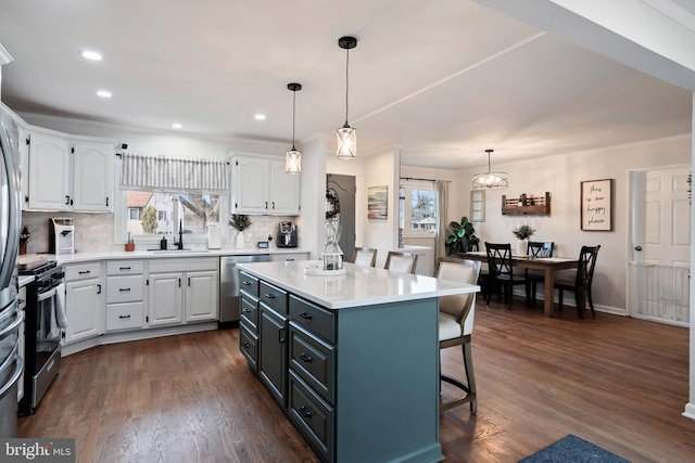 kitchen featuring tasteful backsplash, a center island, white cabinets, and appliances with stainless steel finishes