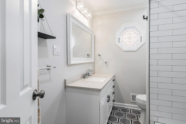 bathroom featuring tile patterned floors, vanity, toilet, and crown molding