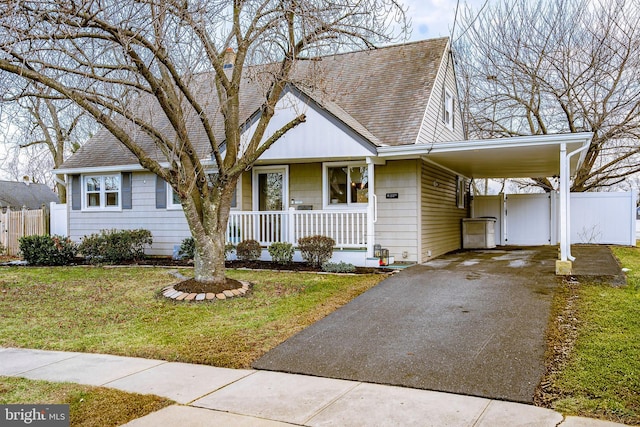 view of front of house with a carport, a porch, and a front yard