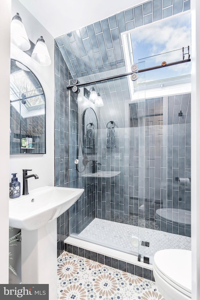 bathroom featuring walk in shower, sink, tile patterned flooring, and toilet