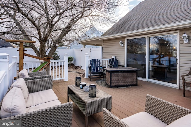 wooden deck featuring an outdoor living space with a fire pit