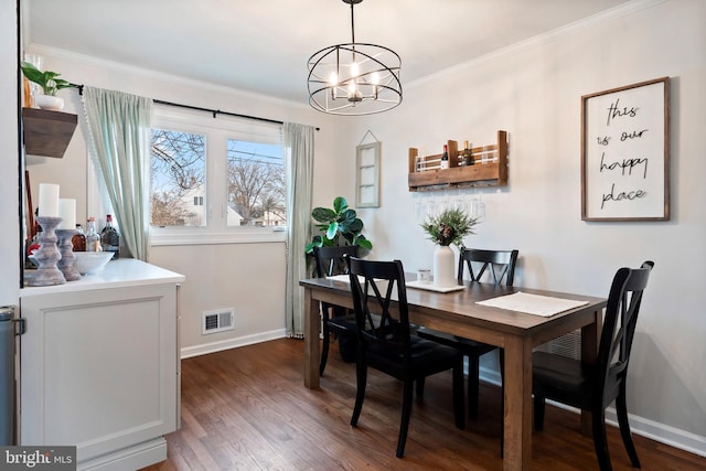 dining space featuring dark hardwood / wood-style flooring, crown molding, and a chandelier