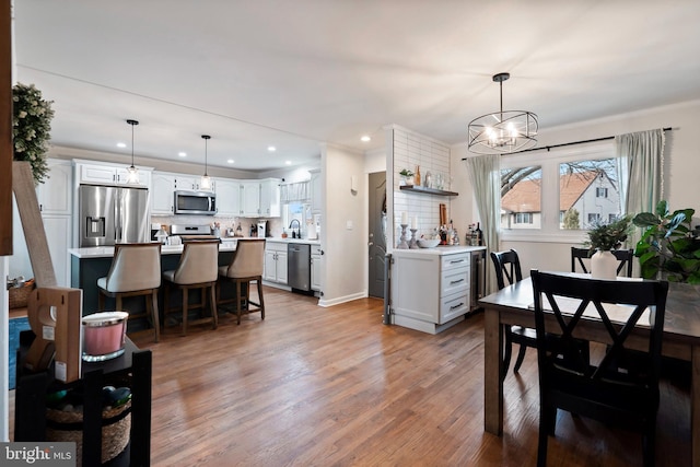 dining area featuring crown molding, a chandelier, sink, and wood-type flooring