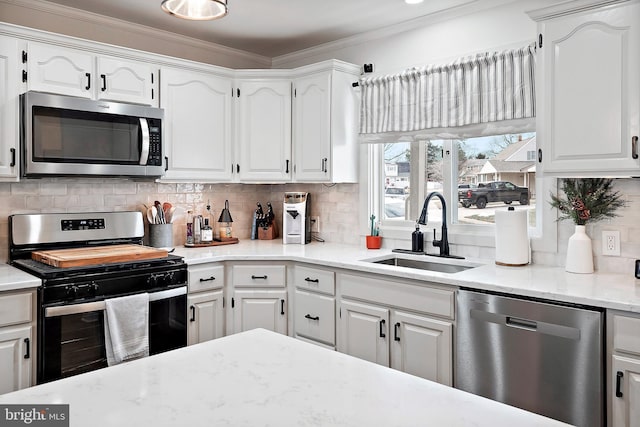 kitchen with sink, white cabinetry, stainless steel appliances, and tasteful backsplash