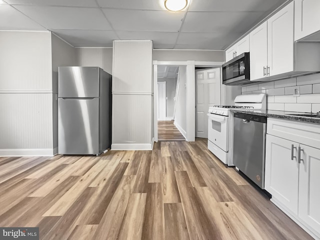 kitchen with white cabinetry, a drop ceiling, stainless steel appliances, and light hardwood / wood-style flooring