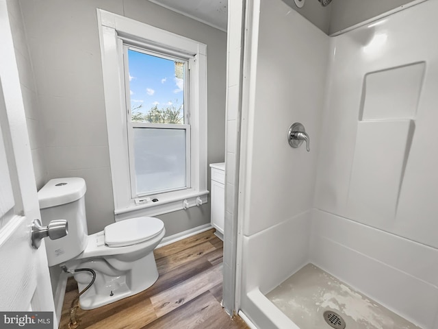 bathroom featuring a shower, toilet, and hardwood / wood-style flooring