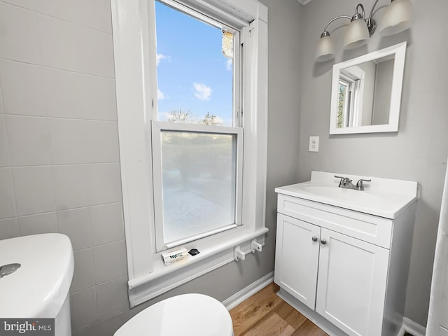 bathroom featuring wood-type flooring, vanity, and toilet