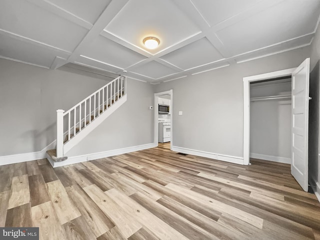 unfurnished living room with hardwood / wood-style floors and coffered ceiling