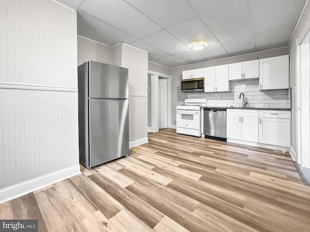 kitchen with a paneled ceiling, white cabinetry, sink, and appliances with stainless steel finishes