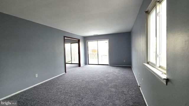 carpeted empty room featuring a wealth of natural light