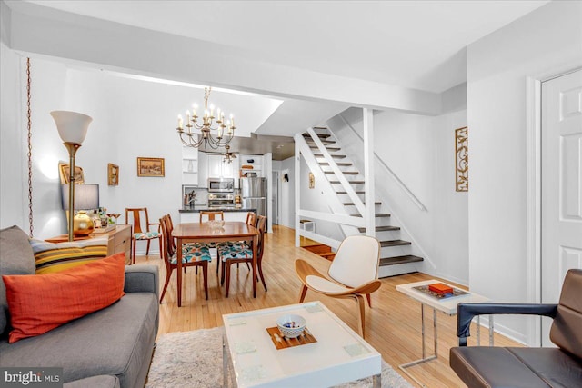 living room with a notable chandelier and light hardwood / wood-style flooring