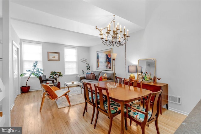 dining room with light hardwood / wood-style floors and a chandelier