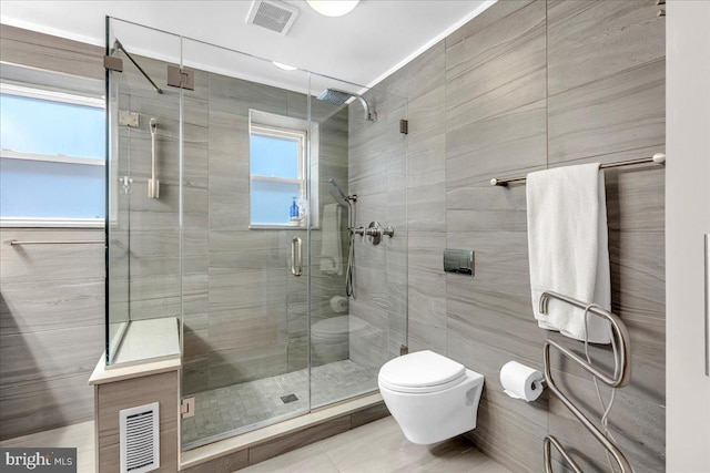 bathroom featuring toilet and a shower with shower door