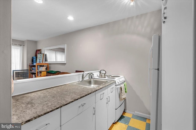 kitchen with sink, white cabinets, and white appliances