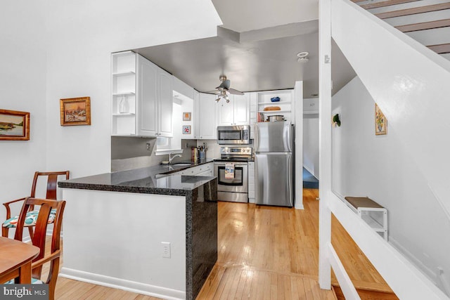 kitchen featuring stainless steel appliances, white cabinets, light wood-type flooring, ceiling fan, and kitchen peninsula