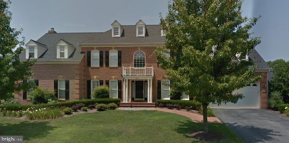 view of front facade with a garage, a balcony, and a front yard