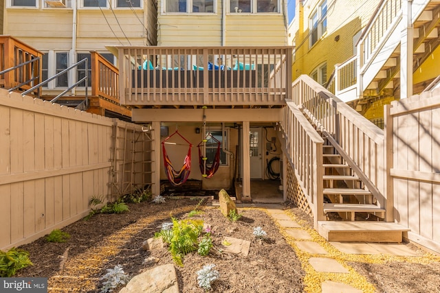 view of exterior entry featuring fence and a wooden deck