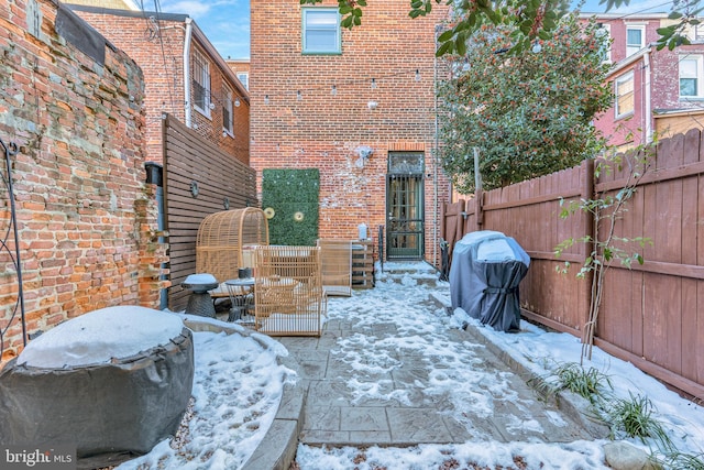 snow covered patio featuring grilling area