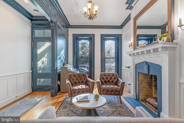 living area featuring a notable chandelier, hardwood / wood-style flooring, and crown molding