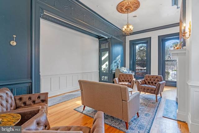 sitting room featuring a chandelier, parquet flooring, and crown molding