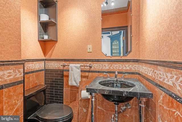 bathroom featuring tile walls, ornamental molding, and toilet