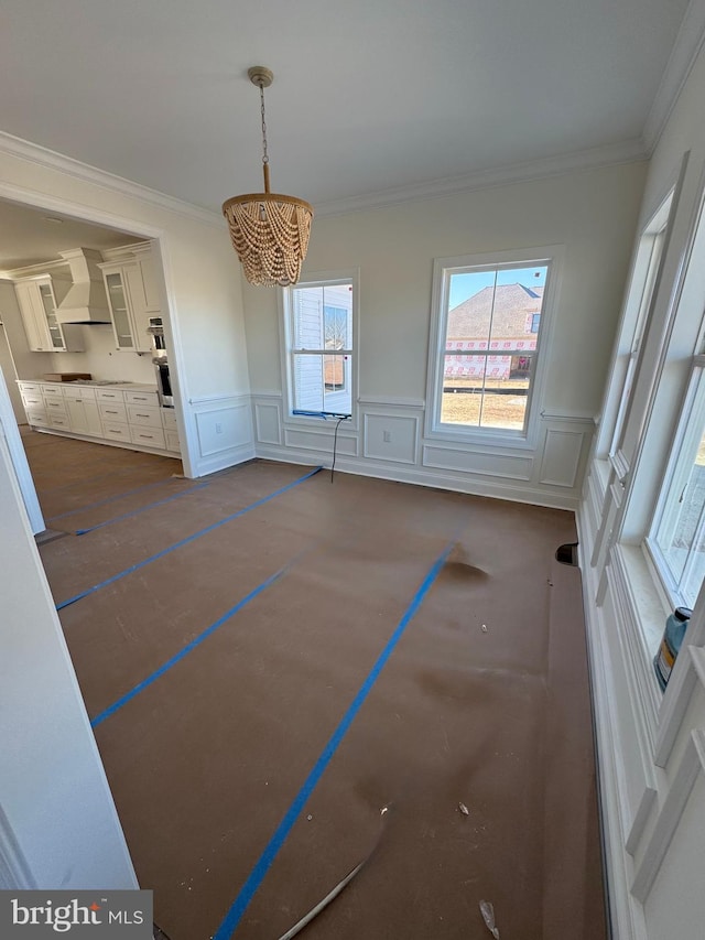 unfurnished dining area featuring crown molding and a chandelier