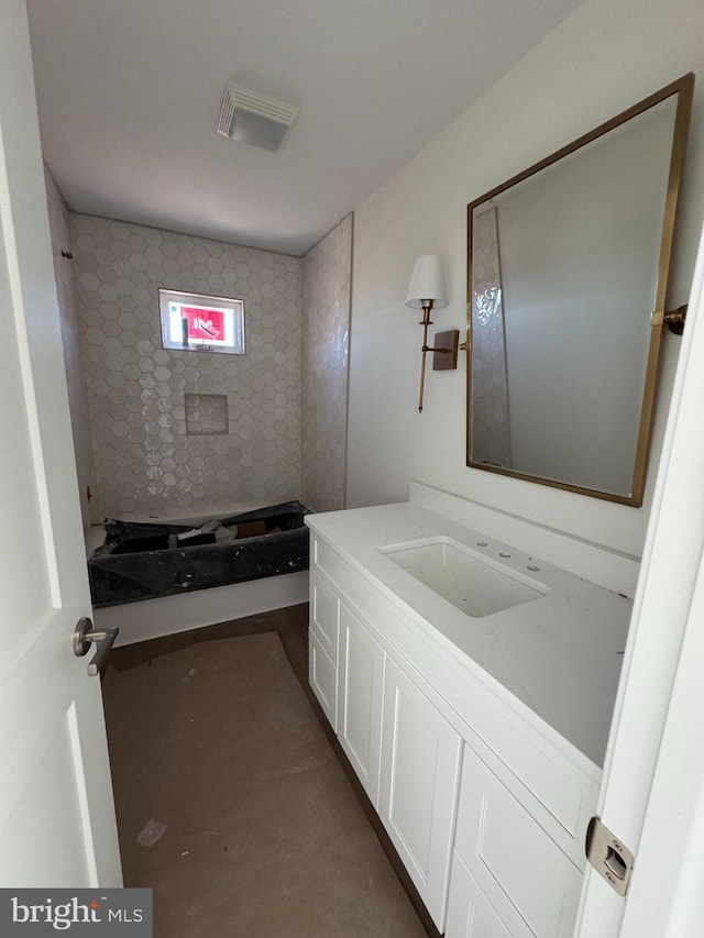 bathroom with concrete flooring, vanity, and a shower