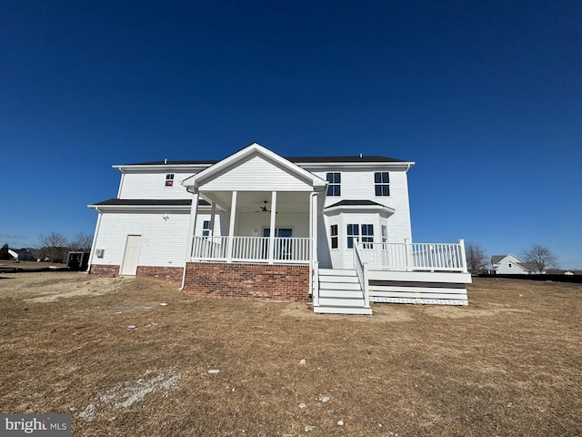 view of front of house featuring covered porch, ceiling fan, and a front lawn