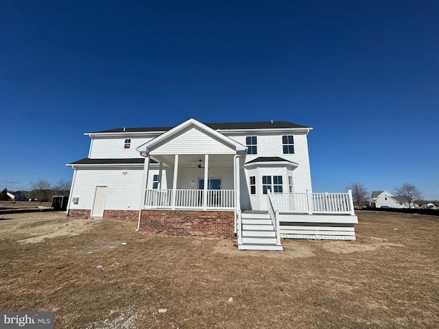 back of property featuring ceiling fan, a porch, and a lawn