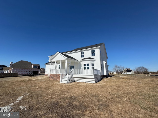 rear view of house with a yard and covered porch